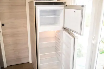 an empty refrigerator with its door open in a room at Camping Bellsol Pets in Pineda de Mar