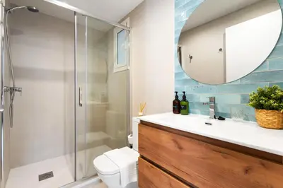a bathroom with a shower and a sink with a mirror at Lodging Apartments Beach Studio 11 in Barcelona