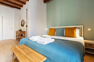 a bedroom with a blue bed with towels on it at Lodging Apartments Beach Studio 11 in Barcelona