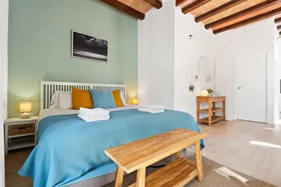 a bedroom with a large bed with a blue blanket at Lodging Apartments Beach Studio 22 in Barcelona