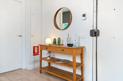 a room with a wooden table with a mirror at Lodging Apartments Beach Studio 41 in Barcelona