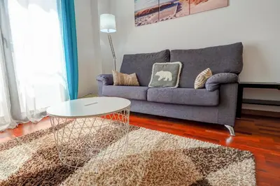 a living room with a couch and a table at Seaside April Apartment by Hello Homes Sitges in Sitges