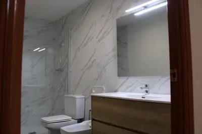 a bathroom with a toilet and a sink and a mirror at Villa Maresme & Villa Rosa in Mataró