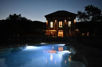a night view of a building with a pool of water at Hotel Montrubí 1771 - Slow Winery Hotel - Adults only in Font-Rubí