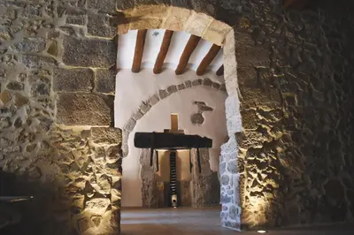 an archway in a stone wall with a cross at Hotel Montrubí 1771 - Slow Winery Hotel - Adults only in Font-Rubí
