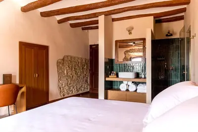 a bedroom with a white bed and a mirror at Hotel Montrubí 1771 - Slow Winery Hotel - Adults only in Font-Rubí