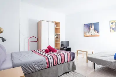 a bedroom with a bed with red pillows on it at Apartamentos Tarradellas Sants Estació in Barcelona