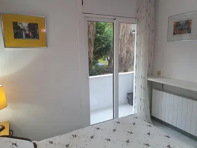 a bedroom with a door leading to a balcony at APARTAMENTO CON OFICINA Y VISTAS AL MAR in Sitges