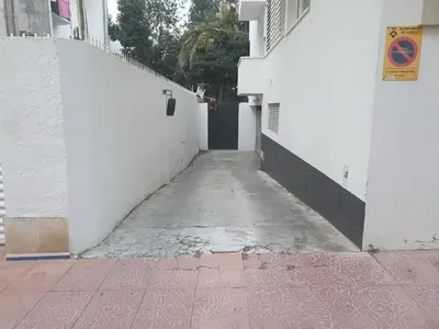 an alley way with a door in a white building at APARTAMENTO CON OFICINA Y VISTAS AL MAR in Sitges