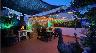 a house with a patio with a table and a fireplace at Apto, Ático Airport BCN, Cruise Port, Near beaches in Viladecáns