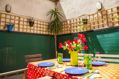 a table with plates and a vase of flowers on it at Apartamento Rosellón in Barcelona