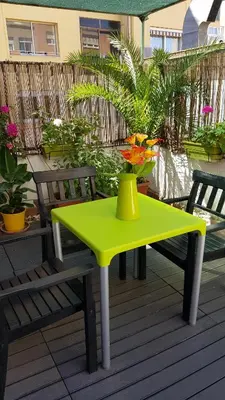 a yellow table and chairs on a deck with a vase on it at Estudio Maignon in Barcelona