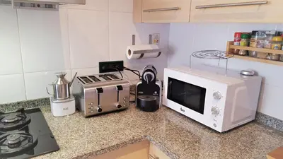 a kitchen counter with a microwave and a stove at Apartamento Mediterraneo in Pineda de Mar