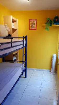 a room with two bunk beds and a yellow wall at Apartamento Mediterraneo in Pineda de Mar