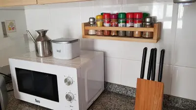 a kitchen with a microwave and a spice rack at Apartamento Mediterraneo in Pineda de Mar
