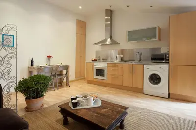a kitchen with a washer and a table in a room at Homenfun Barcelona Montjuic in Barcelona