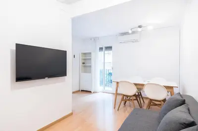 a living room with a table and a tv on a wall at Homenfun Barcelona Gracia in Barcelona