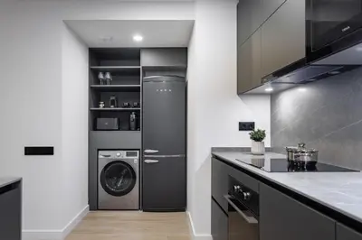 a kitchen with a washer and dryer in a room at ApartsNouBcn Equador Les Corts in Barcelona