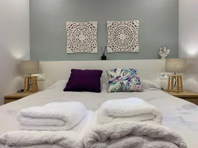 a bed with white blankets and pillows on it at Apartamento Rambla Catalunya in Barcelona