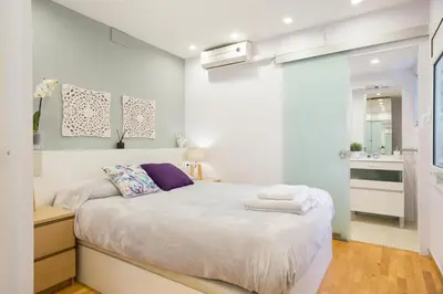 a small bedroom with a bed and a bathroom at Apartamento Rambla Catalunya in Barcelona