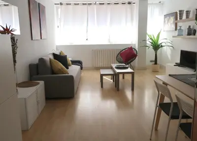 a living room with a couch and a table at Apartments BCN Central-Montjuic in Barcelona