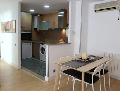 a kitchen with a table and a dining room at Apartments BCN Central-Montjuic in Barcelona