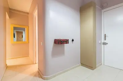 a room with a white wall with a suitcase on the wall at ApartEasy - Plaza España & Fira in Barcelona