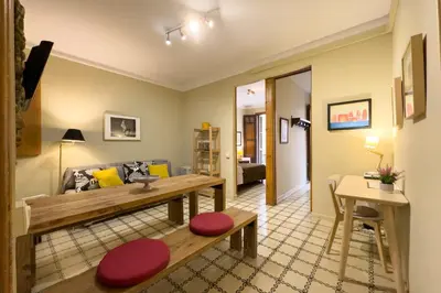 a living room with a bench and a table at ApartEasy - Gracia Apartments in Barcelona
