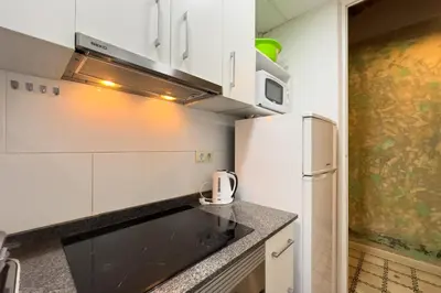 a kitchen with white cabinets and a refrigerator at ApartEasy - Gracia Apartments in Barcelona