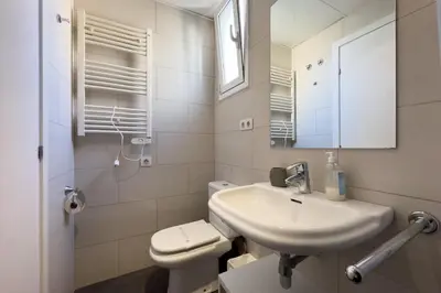 a bathroom with a sink and a toilet and a mirror at ApartEasy - Gracia Apartments in Barcelona