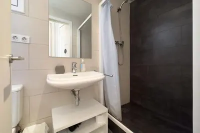 a white bathroom with a sink and a shower at ApartEasy - Gracia Apartments in Barcelona
