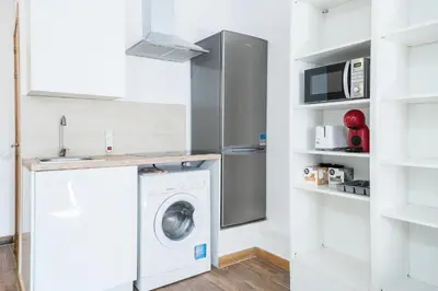 a kitchen with a washing machine and a microwave at Homenfun Barcelona Studio Camp Nou II in Hospitalet de Llobregat
