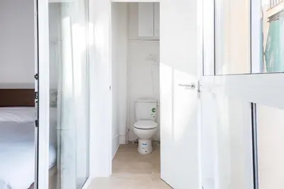 a white bathroom with a toilet and a sink at Homenfun Barcelona Studio Camp Nou II in Hospitalet de Llobregat