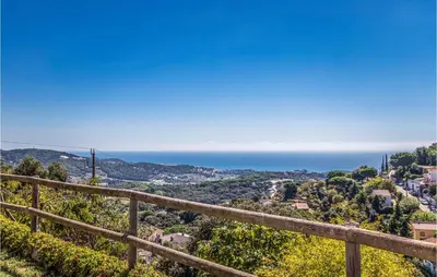 a view of the ocean from a wooden fence at Lovely Home In Sant Cebrià De Vallalta in San Cipriano de Vallalta