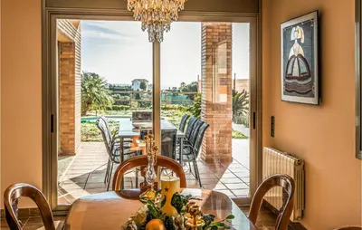 a dining room with a table and a view of a patio at Lovely Home In Sant Cebrià De Vallalta in San Cipriano de Vallalta