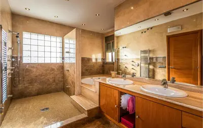 a bathroom with two sinks and a tub and a shower at Lovely Home In Sant Cebrià De Vallalta in San Cipriano de Vallalta
