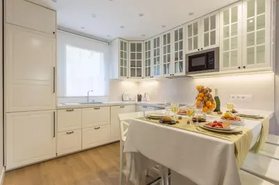 a kitchen with white cabinets and a table with food on it at Moreryadom in Barcelona