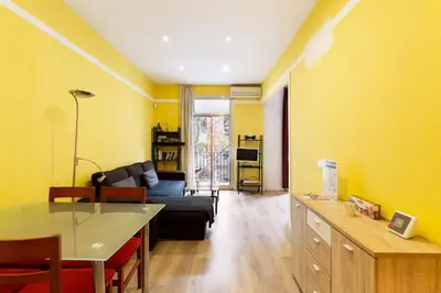 a living room with a black couch and yellow walls at Stay U-nique Apartments Lope de Vega in Barcelona
