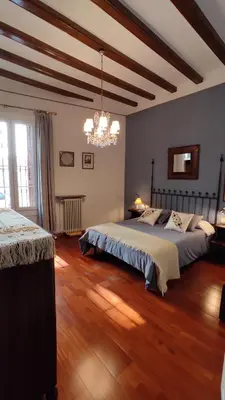 a bedroom with two beds and a chandelier at Casa MO in Sabadell