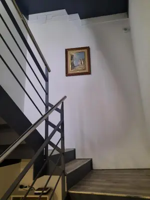 a stairway with a picture on a white wall at Apartaco Apartamentos in Sitges