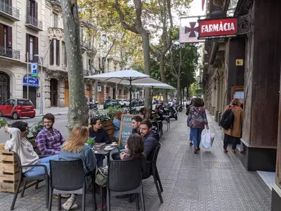 a group of people sitting at tables on a city street at Period Luxury Apartment in Barcelona Prime Location with Street View in Barcelona