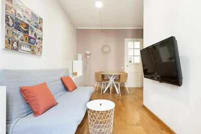 a living room with a blue couch and a flat screen tv at Stay U-nique Apartments Consell in Barcelona