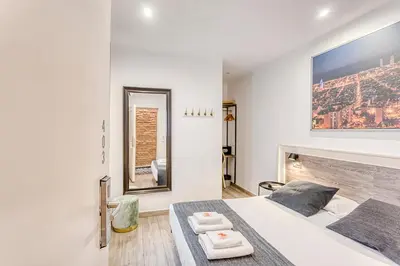 a white bedroom with a bed and a fireplace at HOSTAL BEDMATES in Barcelona