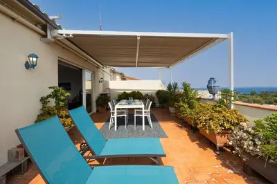 a patio with blue chairs and a table on a balcony at Stay U-nique Apartments Taulat in Barcelona