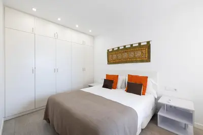 a white bedroom with a bed and white cabinets at Stay U-nique Apartments Taulat in Barcelona