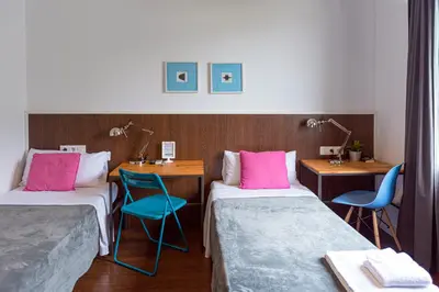 a room with two beds and two tables and chairs at Traveller House in Barcelona