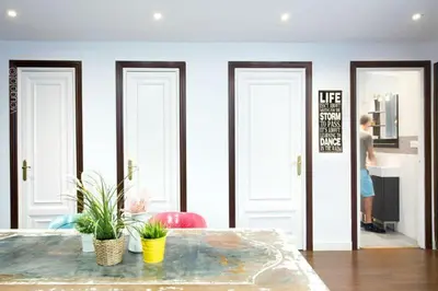 a person standing in a room with three doors at Traveller House in Barcelona