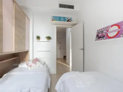 a bedroom with two beds and a hallway at Matarolux23 in Mataró