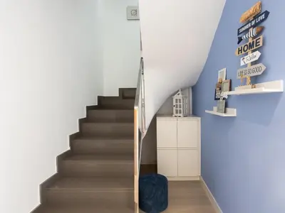 a staircase in a house with a blue wall at Matarolux23 in Mataró