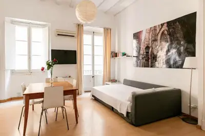 a bedroom with a bed and a table and a dining room at BELLAFILA GOTHIC in Barcelona